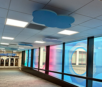 A hallway in the skywalk with clouds hanging from the ceiling.