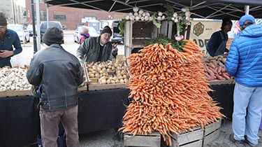 farmers market stall with carrots