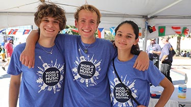 three people wearing world food and music festival shirts