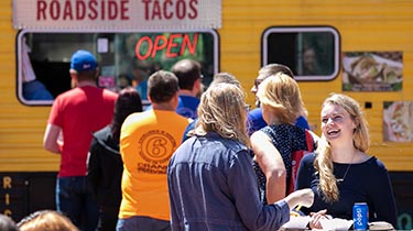 people lining up in front of a food truck