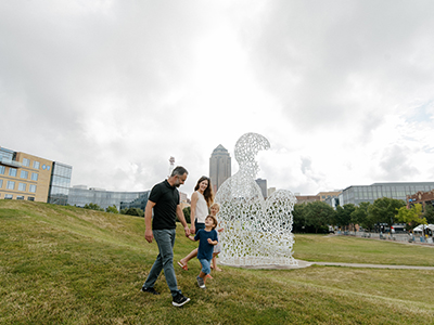 Nomade A family of four walking in front of a large sculpture made of letters