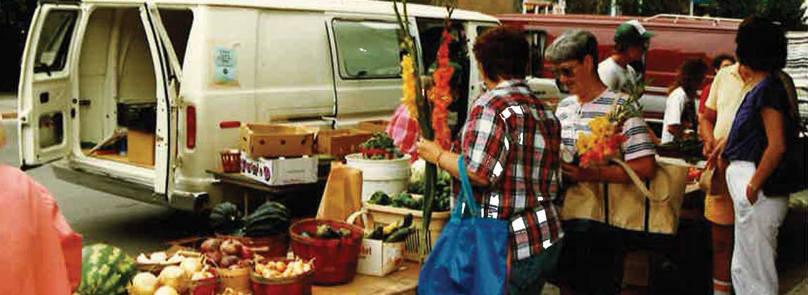 people visiting a Downtown Farmers' Market vendor in th