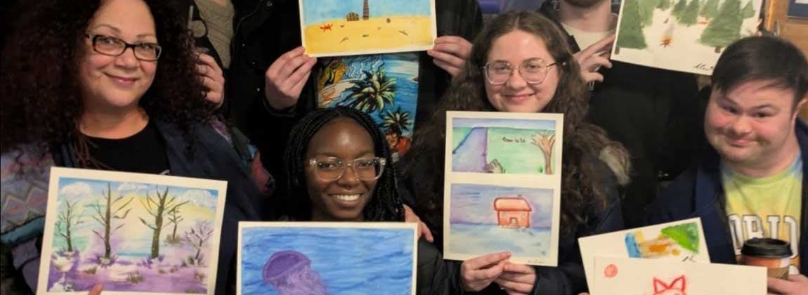 people at Art Night holding paintings