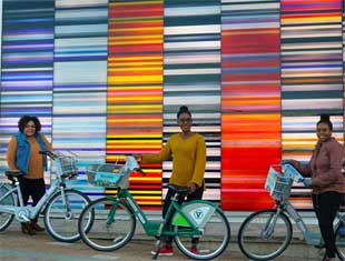 three people posing with bikes
