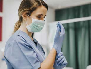 a nurse putting on gloves