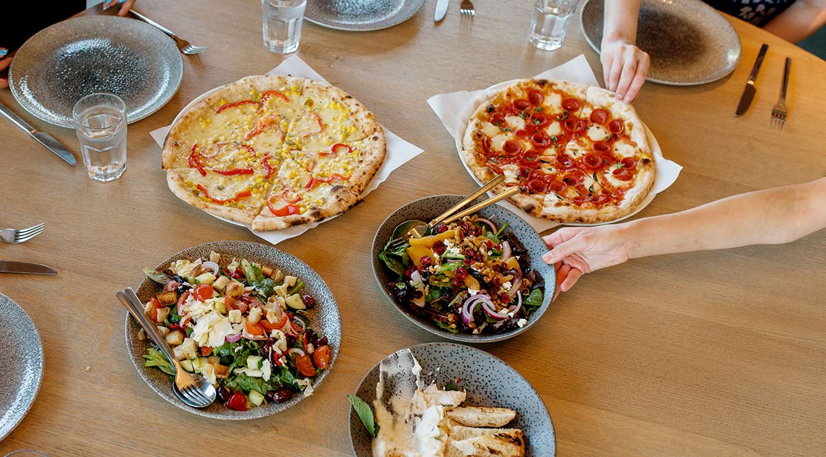 a top-down shot of pizza and salad on a table