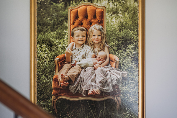 Photo of three siblings hanging on a wall by the stairs