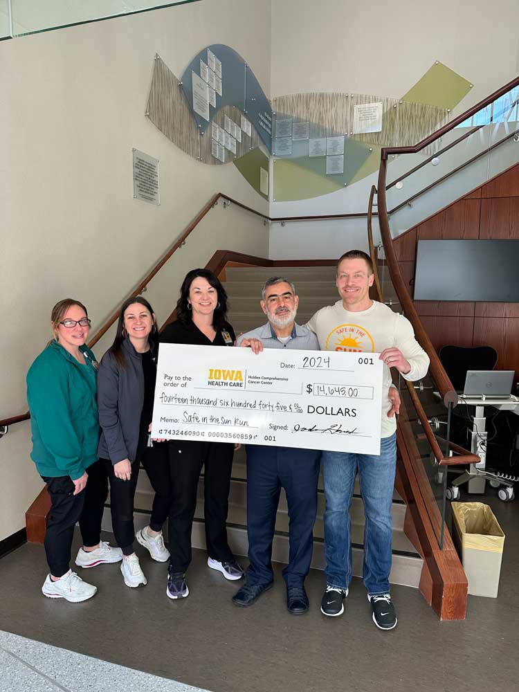 Safe in the Sun Run proceeds people holding giant check