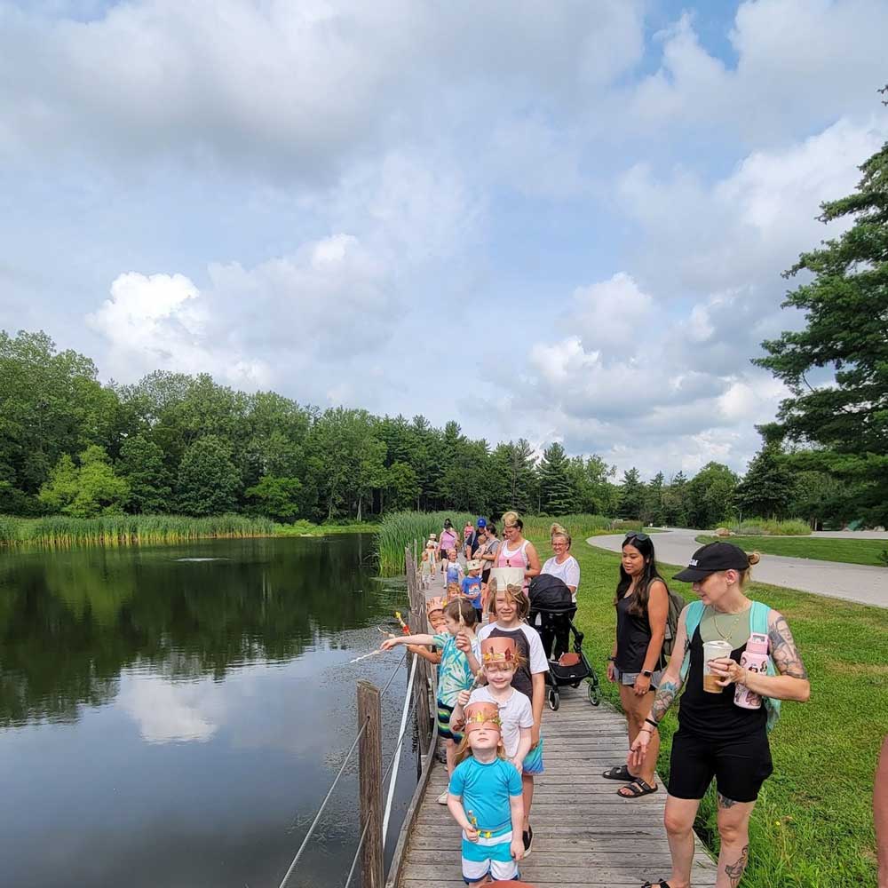 group of people walking near pond