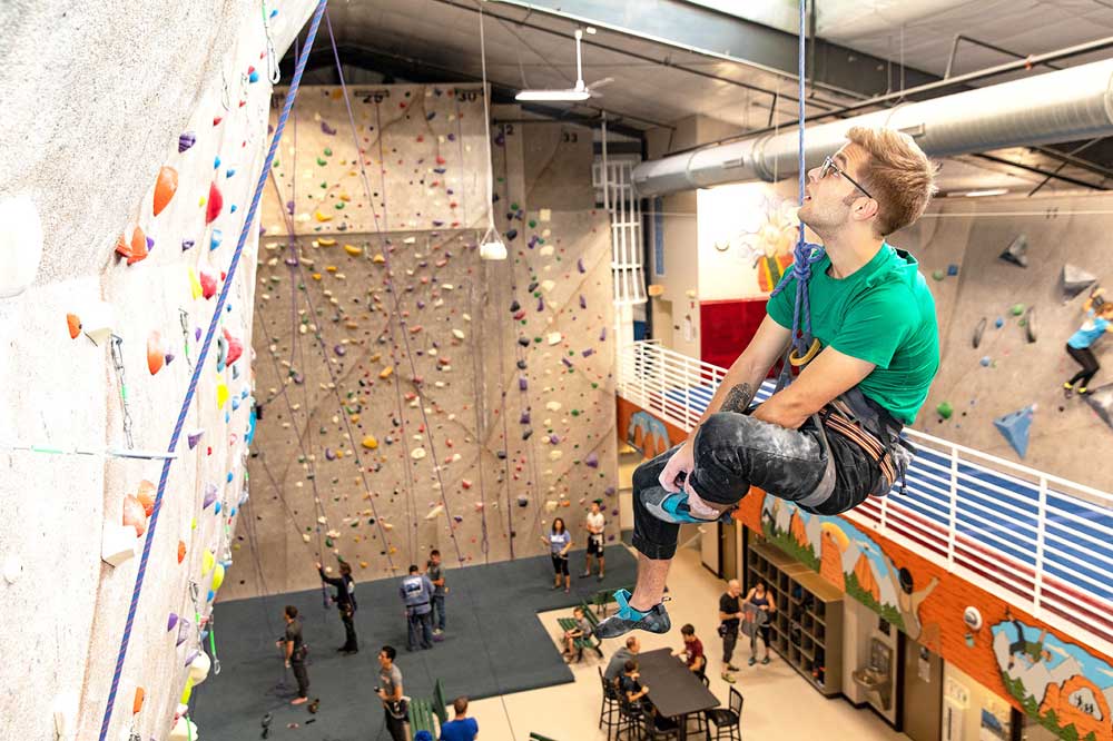 Climb Iowa man climbing rock wall