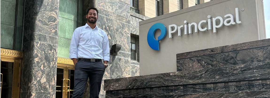Erik DeLuca standing by the Principal sign