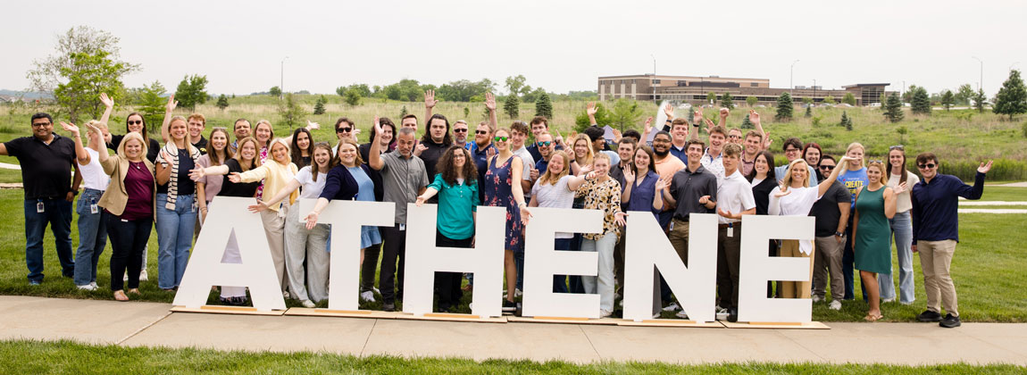 large group of Athene employees posing with letters