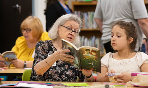 DMPS Volunteer Literacy Program woman reading with student