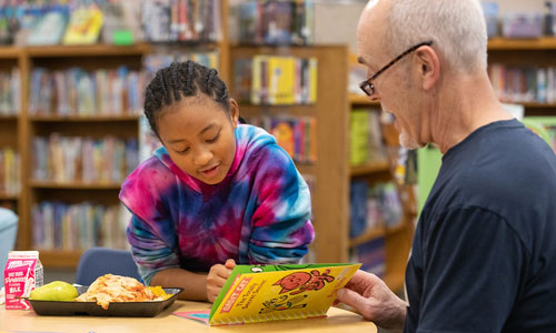 DMPS Volunteer Literacy Program man reading with student