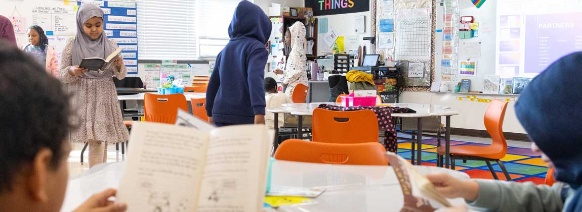 students with books in school classroom
