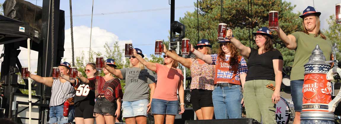people on stage cheers to Oktoberfest
