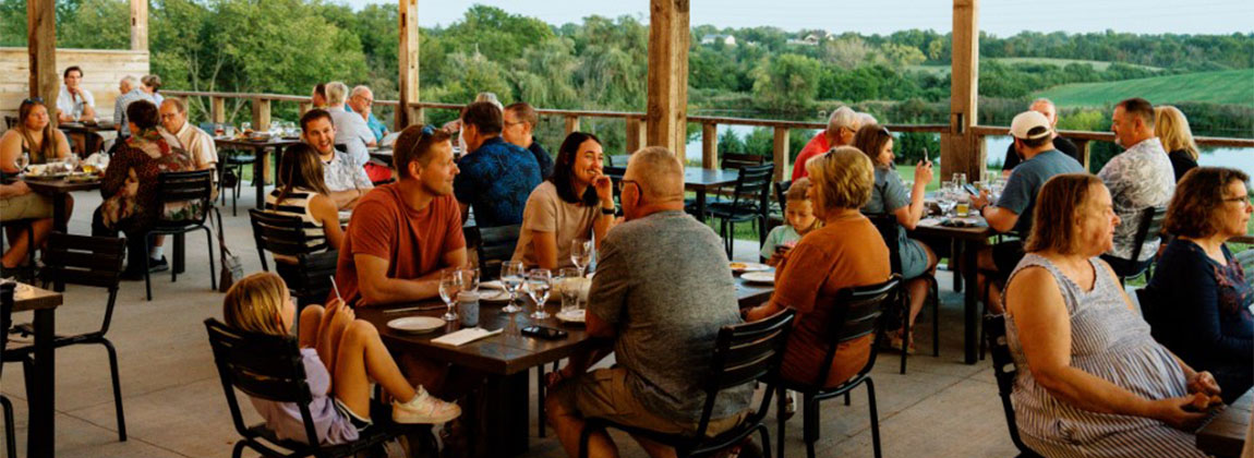 A patio full of people dining and laughing at tables.