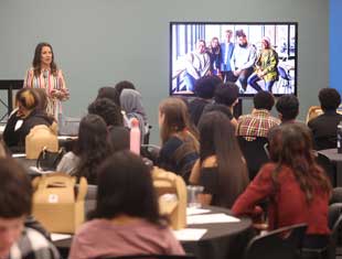 a woman speaking to a group of students