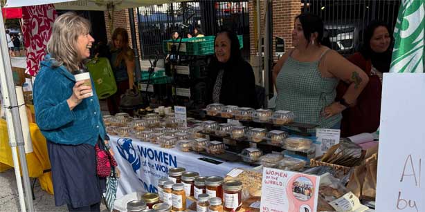 woman with coffee at a farmers' market booth