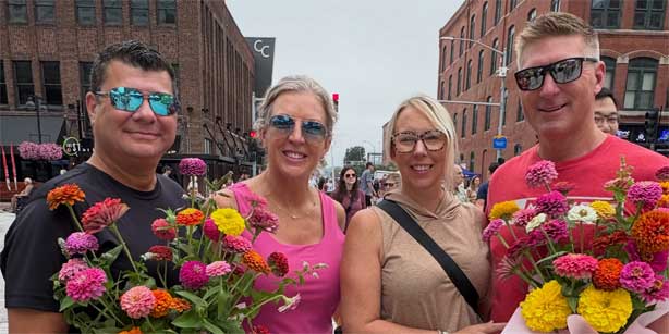 four people with flowers at The Market