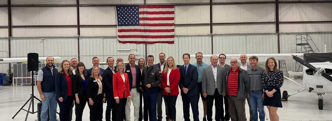 group posing in airport hangar