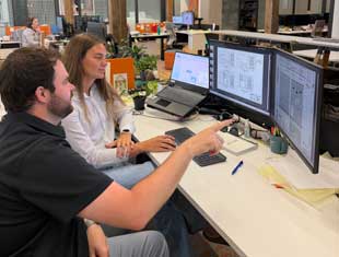 Kate Hoover and CMBA employee look at computer monitors