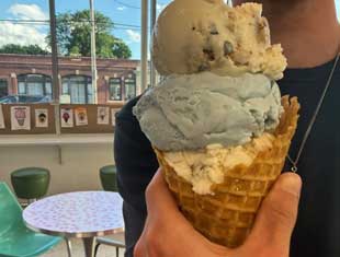 three scoops of ice cream in a waffle cone