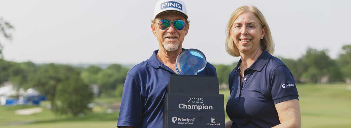 two people posing with golf classic trophy