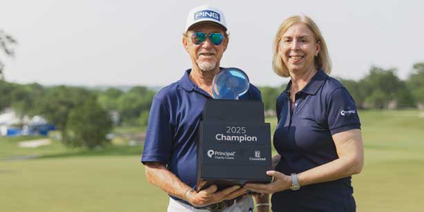 two people posing with golf classic trophy