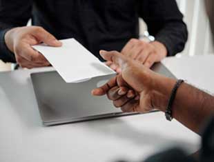 a person handing another person a paper