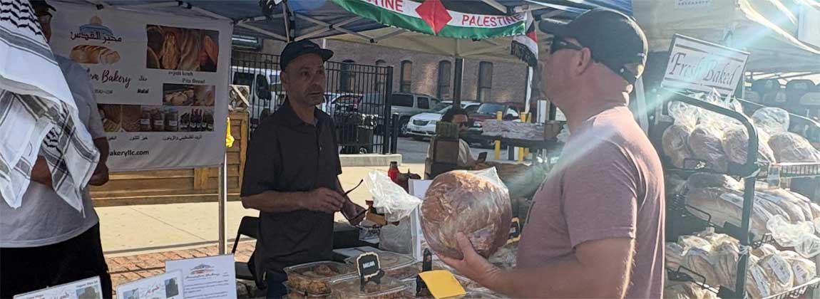 man buying from a farmers' market vendor
