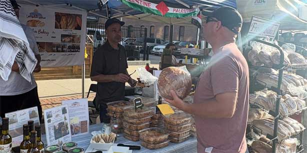 man buying from a farmers' market vendor