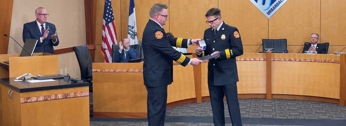 two men shake hands at city council meeting