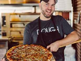 a man holding a pizza