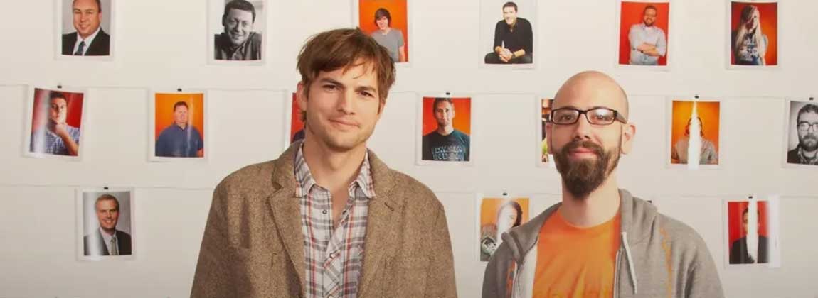 two people posing in front of photographs