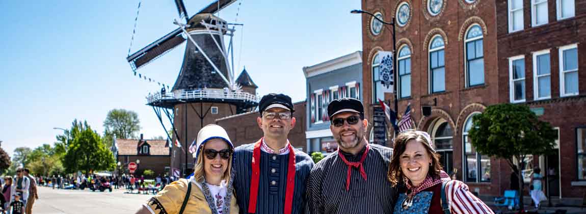 four people in front of a windmill
