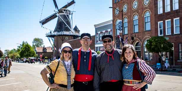 four people in front of a windmill