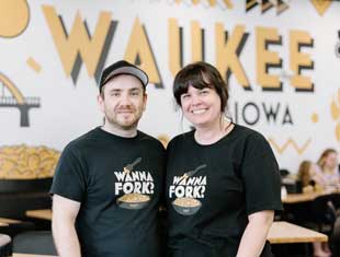 two people posing in front of a Waukee, Iowa mural