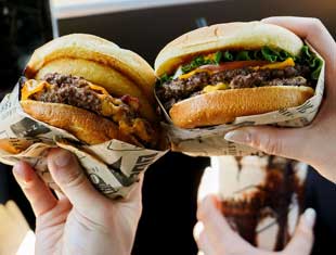 hands holding burgers