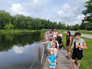 group of people walking near pond