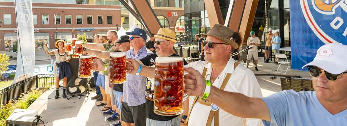 people on stage with beer steins