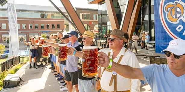 people on stage with beer steins
